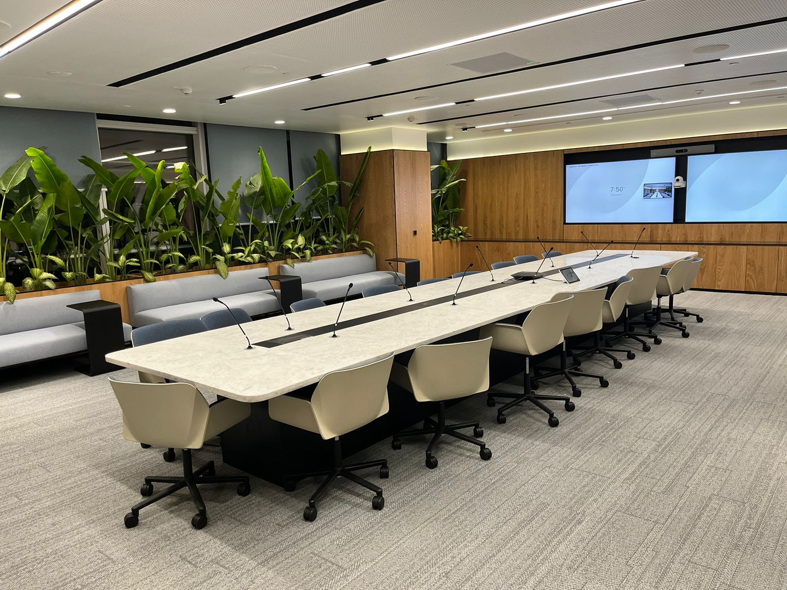 A boardroom with conference video display and Microsoft Teams room interface designed by VELOtech